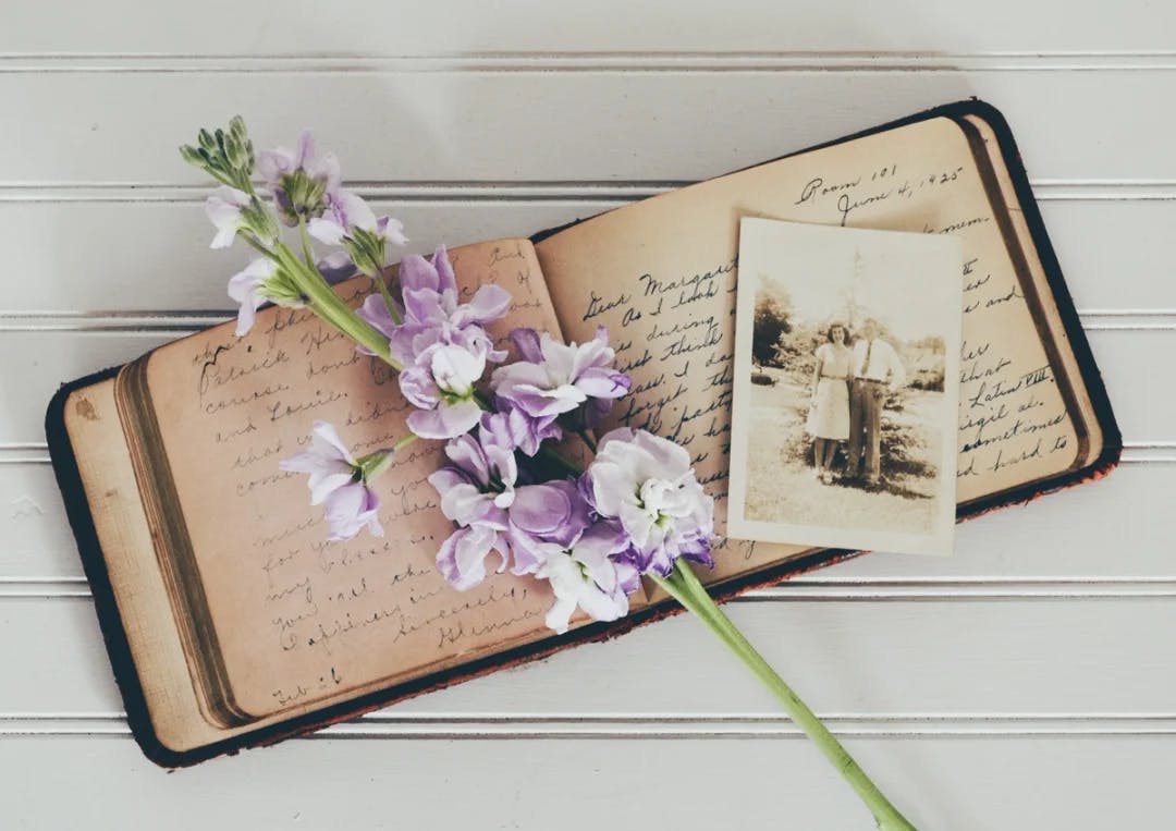 Gammel dagbok, gammelt bilde og en blomsterstilk